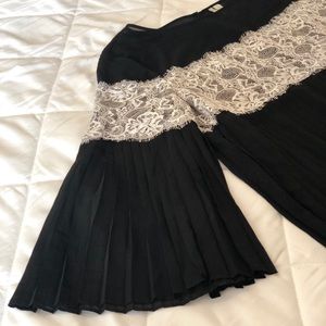 Black pleated blouse with white lace.
